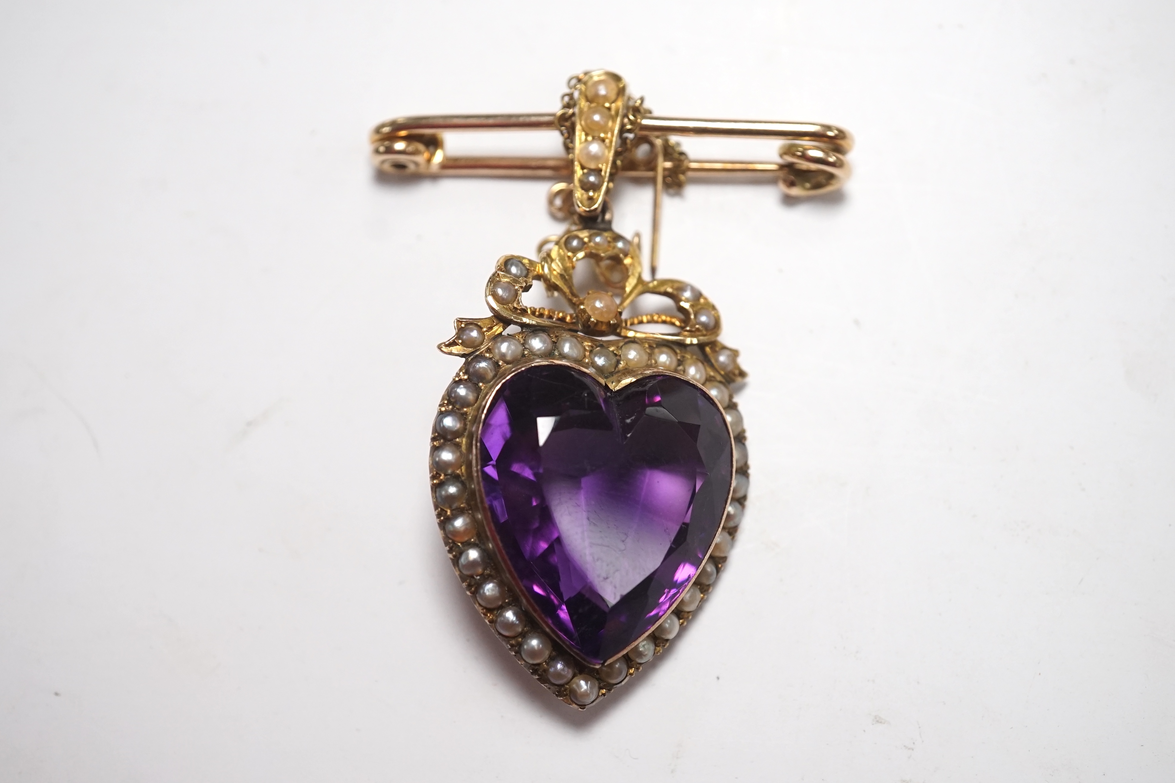 A late Victorian yellow metal amethyst and split pearl cluster set heart shaped pendant, overall 48mm, with later attached 9ct gold brooch attachment, gross weight 14 grams. Condition - fair to good